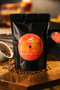 45 Zero-Emission Micro-Roasted Sustainable Medium Roast Coffee | Premium Specialty Coffee | Best coffee in Athens GA | Front of black package ​​sitting on table of coffee beans